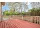 Back deck surrounded by an unfenced lawn with a wooden fence and scattered trees at 134 N Alexander St, Buford, GA 30518