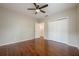 Bedroom with hardwood floors, ceiling fan, and large closet with adjacent view into another room at 134 N Alexander St, Buford, GA 30518