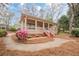 Inviting single-story home showcasing a wide front porch with steps and natural landscaping with shrubs and mulch at 134 N Alexander St, Buford, GA 30518