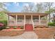 Charming single-story home featuring a welcoming front porch with painted steps and manicured landscaping at 134 N Alexander St, Buford, GA 30518