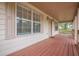 Wide front porch includes painted wood flooring, exterior lighting, railings, and shade from the covered roof at 134 N Alexander St, Buford, GA 30518