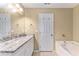 Bright bathroom featuring a granite countertop, white cabinets, tub, and large mirror at 2996 Jonesboro Road Southeast Se Rd # J, Atlanta, GA 30354