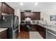 View of the kitchen with stainless steel appliances, dark cabinetry, granite countertops, and hardwood floors at 3504 Castleberry Village Cir # 36, Cumming, GA 30040