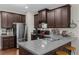 Modern kitchen featuring stainless steel appliances, dark cabinetry, granite countertops, and a double-basin sink at 3504 Castleberry Village Cir # 36, Cumming, GA 30040