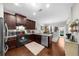 Open concept kitchen with stainless steel appliances, dark cabinets, granite countertops, and hardwood floors at 3504 Castleberry Village Cir # 36, Cumming, GA 30040