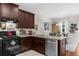 View of the kitchen with a stainless dishwasher, dark cabinetry, and dining table and chairs in the background at 3504 Castleberry Village Cir # 36, Cumming, GA 30040