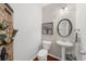 Cozy powder room featuring a pedestal sink, decorative mirror, and unique wall decor at 3504 Castleberry Village Cir # 36, Cumming, GA 30040