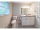 A bathroom features a granite vanity, toilet, and neutral walls, creating a clean, functional space at 4457 Lincoln Jones Rd, Ellenwood, GA 30294