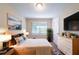 A staged bedroom features a bed, nightstands, artwork, and a dresser with decor at 4457 Lincoln Jones Rd, Ellenwood, GA 30294