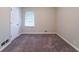 A bedroom includes neutral walls, carpet flooring, a window and a white paneled door at 4457 Lincoln Jones Rd, Ellenwood, GA 30294