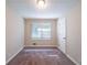 A bedroom features neutral walls, carpet flooring, a window, and a white paneled door at 4457 Lincoln Jones Rd, Ellenwood, GA 30294