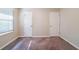 A bedroom includes neutral walls, carpet flooring, a window, and two white paneled doors at 4457 Lincoln Jones Rd, Ellenwood, GA 30294