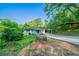 Charming one-story home featuring a long driveway and mature trees on a lush, green lot at 4457 Lincoln Jones Rd, Ellenwood, GA 30294