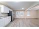 View of kitchen cabinets and appliances and adjacent open living room space with modern flooring at 4457 Lincoln Jones Rd, Ellenwood, GA 30294