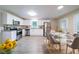 Bright kitchen and dining area featuring white cabinets, stainless steel appliances, and modern flooring at 4457 Lincoln Jones Rd, Ellenwood, GA 30294