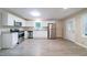 Well-lit kitchen with modern stainless steel appliances, clean white cabinets and sleek gray laminate flooring at 4457 Lincoln Jones Rd, Ellenwood, GA 30294