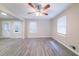 Living room with large windows and fan that adjoins an open kitchen at 4457 Lincoln Jones Rd, Ellenwood, GA 30294