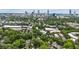 Wide aerial view of a neighborhood with mature trees, businesses, and the city skyline in the distance at 797 Ashland Ne Ave, Atlanta, GA 30307