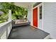 Inviting porch with a porch swing and vibrant red door, surrounded by lush greenery and privacy at 797 Ashland Ne Ave, Atlanta, GA 30307