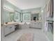 Bright bathroom featuring double vanities, a soaking tub, and natural light from large windows at 290 Bluff Oak Dr, Roswell, GA 30076