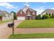 Charming two-story red brick home with manicured lawn and inviting front porch at 290 Bluff Oak Dr, Roswell, GA 30076