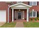 Inviting front porch with classic columns, black door, and brick detailing at 290 Bluff Oak Dr, Roswell, GA 30076