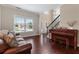 Inviting living room with hardwood floors, a piano, and ample natural light from the large window at 290 Bluff Oak Dr, Roswell, GA 30076