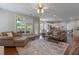 Open-concept living room with white kitchen, ceiling fan, hardwood floors, and view of the backyard at 290 Bluff Oak Dr, Roswell, GA 30076