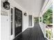 Close up of a lovely covered porch featuring dark wood floors and white trim at 308 Golden Ct, Canton, GA 30114