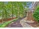 Landscaped backyard with a stone path leading to a spacious deck and lush greenery at 335 S Satinwood Pl, Roswell, GA 30076