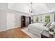Well-lit bedroom features hardwood floors, a tray ceiling, and windows with decorative shutters at 335 S Satinwood Pl, Roswell, GA 30076