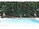 Community pool with lounge chairs and umbrellas surrounded by mature trees at 335 S Satinwood Pl, Roswell, GA 30076