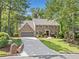 Charming two-story brick home with an attached garage, long driveway, and mature trees at 335 S Satinwood Pl, Roswell, GA 30076