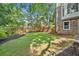 Well-manicured front yard with green grass and mature landscaping enhances curb appeal of brick home at 335 S Satinwood Pl, Roswell, GA 30076
