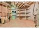 Unfinished basement with wood shelving and concrete floor at 5121 Hope Sw Ct, Lilburn, GA 30047