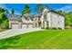 Beautifully landscaped front lawn leading up to a two-story brick home with a three-car garage at 5121 Hope Sw Ct, Lilburn, GA 30047