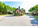 Community entrance with brick gate house and wrought iron gates, surrounded by mature trees at 5121 Hope Sw Ct, Lilburn, GA 30047