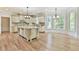 Open kitchen design with hardwood floors, large island, custom cabinets, granite countertops, and stainless steel appliances at 5121 Hope Sw Ct, Lilburn, GA 30047