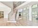 Open-concept living room with hardwood floors, large windows, and a view of the staircase at 5121 Hope Sw Ct, Lilburn, GA 30047