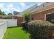 View of the brick exterior and lawn with privacy bushes and partial covered patio view at 5250 Villa Lake Ct, Suwanee, GA 30024