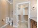 Well-lit bathroom featuring a toilet, vanity with plenty of storage, and a walk-in closet at 5250 Villa Lake Ct, Suwanee, GA 30024