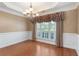 Formal dining room with hardwood floors, wainscoting, and chandelier lighting at 5250 Villa Lake Ct, Suwanee, GA 30024