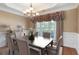 Formal dining room boasts a tray ceiling, elegant chandelier, and beautiful window views at 5250 Villa Lake Ct, Suwanee, GA 30024