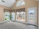 Living room with a vaulted ceiling, windows overlooking a patio, and access to the backyard at 5250 Villa Lake Ct, Suwanee, GA 30024