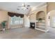 Cozy living room with a fireplace, built-in shelves, and large windows overlooking the yard at 5250 Villa Lake Ct, Suwanee, GA 30024
