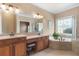 Main bathroom featuring dual sinks, vanity, garden tub, and glass enclosed shower at 5250 Villa Lake Ct, Suwanee, GA 30024