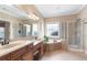 Main bathroom featuring dual sinks, vanity, garden tub, and glass enclosed shower at 5250 Villa Lake Ct, Suwanee, GA 30024