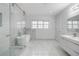 Bright bathroom featuring marble tile, standalone tub, glass enclosed shower, and modern vanity at 773 Minor Oaks Nw Run, Lilburn, GA 30047