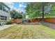Spacious backyard with wood fence, mature trees, and a charming swing set at 12060 Carriage Park Ln, Duluth, GA 30097