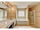 Bright bathroom featuring a separate tub and shower, and a long vanity with dual sinks at 12060 Carriage Park Ln, Duluth, GA 30097